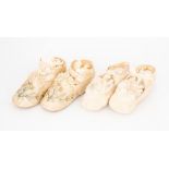 Two pairs of cream babies shoes, one pair is of an embroidery line with silk rosette detail and