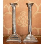 A pair of Edwardian electroplated Corinthian column candle holders, circa 1910, of typical form on