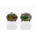 A pair of black opal and silver stud earrings, the oval opals measuring approx. 7.5mm x 5mm, set