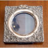 A silver mounted photo frame with embossed decoration.