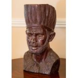 An African carved wood bust, 20th Century, modelled as a bearded man with tall feathered