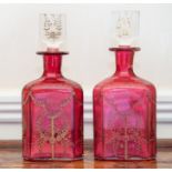 A pair of cranberry glass decanters and stoppers,