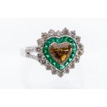 A diamond and emerald heart shaped 18ct white gold ring, comprising a heart cut champagne diamond