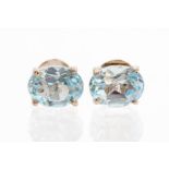 A pair of blue topaz and silver studs, oval faceted peridots set in four claw mounts, size approx