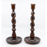 A pair of Edwardian turned oak candlesticks, of barley-twist form, 30cm high. (2)