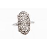 A diamond and platinum ring, comprising a lozenge shaped setting with three round brilliant cut