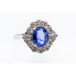 A sapphire and diamond 18ct white gold cluster ring, comprising a central oval sapphire approx.