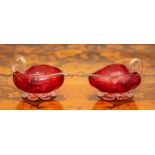 A pair of cranberry glass leaf-shaped salts with white metal spoons.