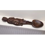 A reproduction carved wood loving spoon modelled as a pilgrim on horseback.