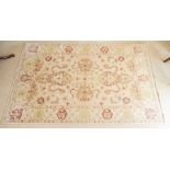 An Agra Indian rug, modern, woven with stylised flowers and foliage on a pale ivory ground, 190cm