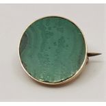 A precious yellow metal and malachite set circular brooch, (yellow metal assessed as 14ct. gold),