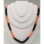 A pink coral, yellow metal bead and black bead necklace, with cabochon pink coral set silver