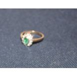 A 9ct. gold, emerald and diamond ring, bezel set oval cut emerald to centre and twelve round cut