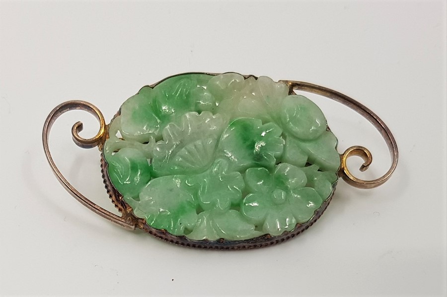 A silver gilt mounted mottled green jade floral brooch, pierced and carved, length 5.5cm.