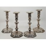 A matched set of four George II cast silver candlesticks, comprising two pairs, both pairs by