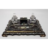 A Victorian mother of pearl inlaid papier mache desk stand, with twin glass inkwells flanking lidded