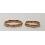 Two matching 14ct. two-tone gold wedding bands, both having textured white gold inlaid into a yellow