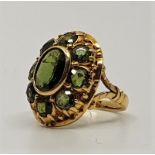 An 18ct. yellow gold and peridot dress ring, having domed setting with bezel set oval cut peridot to