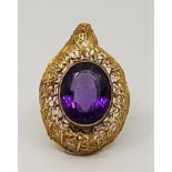 A large precious yellow metal and amethyst pendant, having single large oval mixed cut amethyst