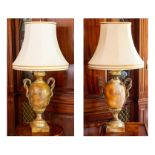 A pair of decorative table lamps, decorated with entwined serpents, with cream shades, full height