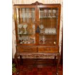 A burr walnut vitrine on stand of Queen Anne design, twin frieze drawers, serpentine carved apron,