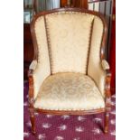 A wing back armchair, carved frame, gold damask upholstery Note: located at the vendor's property in