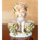 A late 19th Century European hard paste triple spill vase, moulded as a cherub with florally