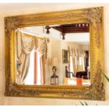 A large gilt framed wall mirror with scroll frame, 130cm by 160cm Note: located at the vendor's