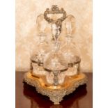 A triple glass decanter set in a plated foliate stand Note: located at the vendor's property in