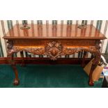 A mahogany console table of Adam design, carved frieze and serpentine apron, cabriole legs, claw and