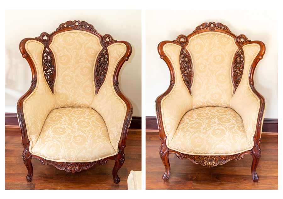 A pair of recent wing back armchairs, damask upholstery, carved lovebirds to the top rails (2) Note: