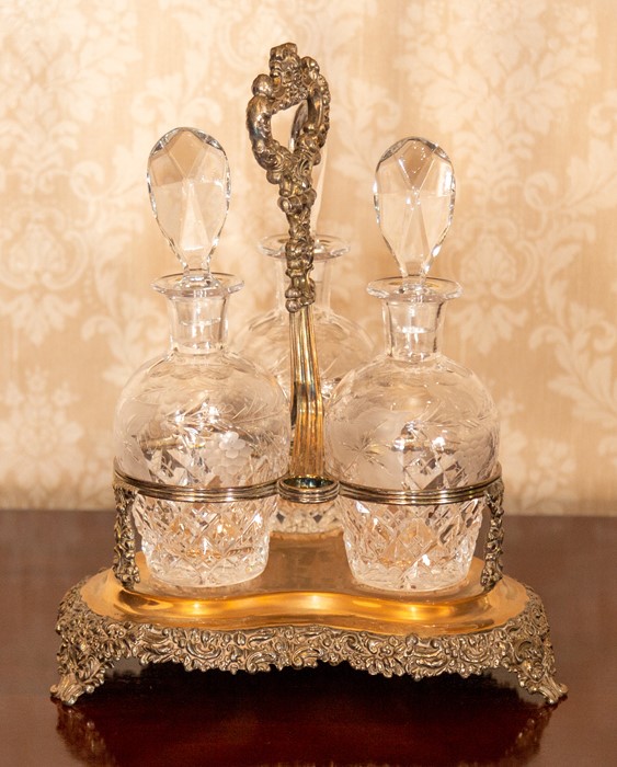 A triple glass decanter set in a plated foliate stand Note: located at the vendor's property in - Image 2 of 2