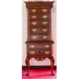A mahogany chest on stand, of Georgian design, carved throughout. the upper section with six