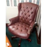 A swivel office armchair with button leather upholstery and studded detail Note: located at the