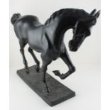 A 19th Century large bronze horse, its head facing down, standing on a plinth base