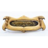 An Edwardian art nouveau brass door letter plate, circa 1900-1910, of double-scroll form, with