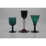 An early 19th Century green glass wine glass, the basal-fluted conical bowl above a knopped stem and