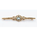 An early 20th Century 9ct gold topaz and diamond bar brooch, the central stone surrounded by four