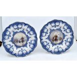 Royal Crown Derby: Two blue and white plates with painted centres showing maritime scenes, signed by