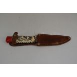 A circa 1960's camping knife with a 9cm blade complete with leather scabbard marked "Lulworth Cove".