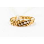 An early 20th Century diamond and 18ct gold ring, five graduated diamonds set within a border,