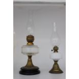 Two Victorian oil lamps, one with a clear glass reservoir, the other with an opaline glass reservoir