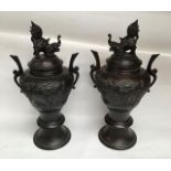 Pair Bronze twin handled Urns with covers, damage to one handle. 34cm tall including cover.