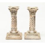 A pair of late Victorian desk candlesticks, Corinthian column capitals above twisted columns, on