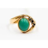 An 18ct gold ladies dress ring, comprising a cabochon oval cut turquoise, rub-over set with three