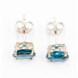 A pair of blue topaz and silver studs, comprising swiss blue oval cut topaz approx. 8 x 5mm, claw