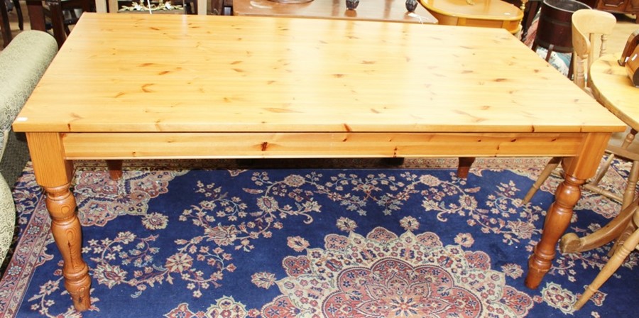 A contemporary solid pine kitchen table, standing on turned supports, 76cm high, 183cm wide, 91cm