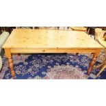 A contemporary solid pine kitchen table, standing on turned supports, 76cm high, 183cm wide, 91cm