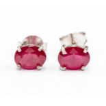 A pair of ruby and silver studs, comprising oval cut rubies approx. 7x 5mm, claw settings with