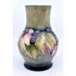 A Moorcroft 1930s Grape and Leaf design bulbous vase, with bottle neck, tube lined decoration on a